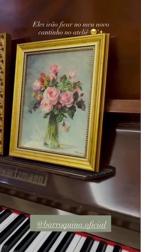 Dois quadros com molduras douradas sobre um piano de madeira